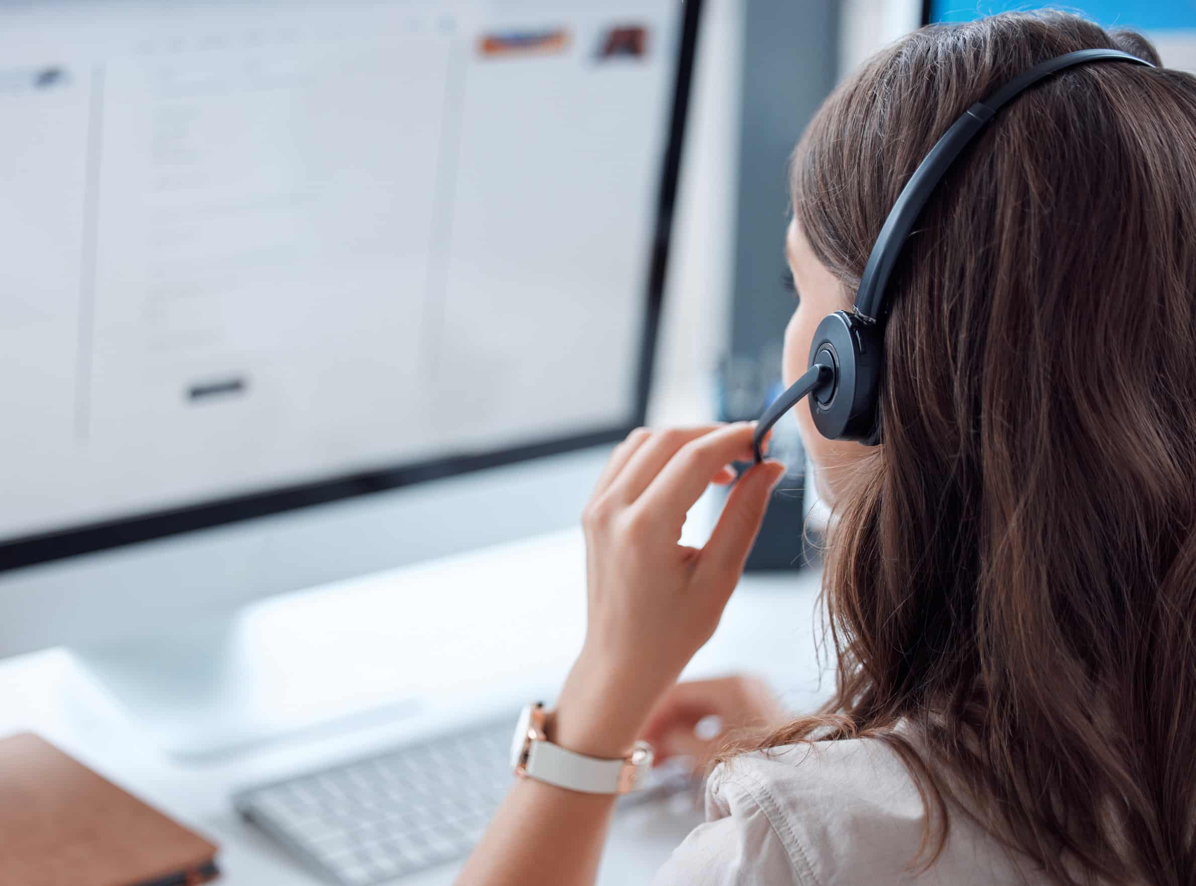 Customer support, call center and back of female agent working on online consultation in the office. Telemarketing, communication and saleswoman planning crm with headset and computer in workplace.